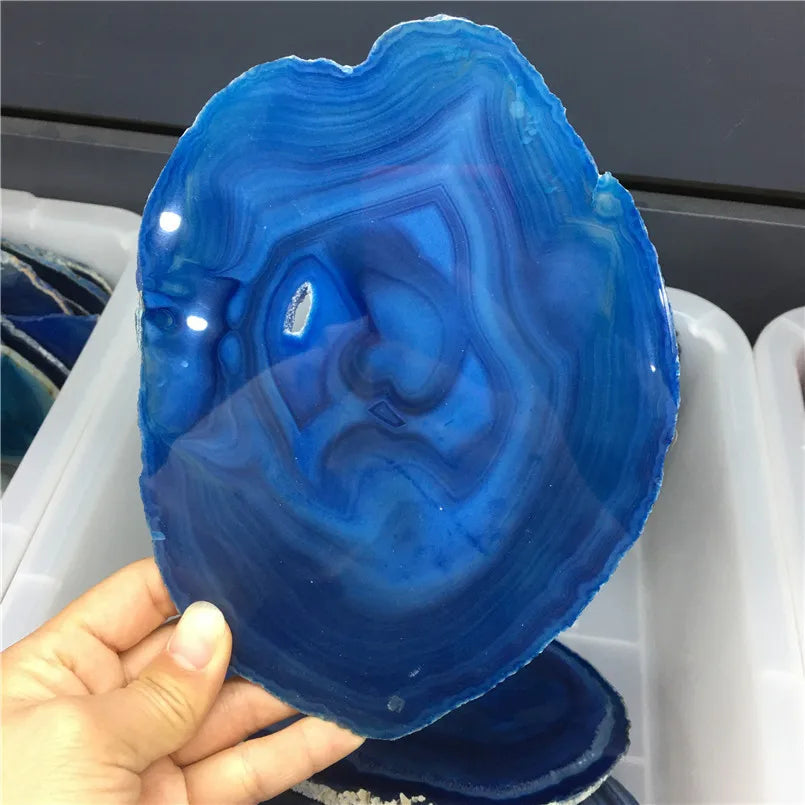 Blue agate stone held in a hand with a blurred background