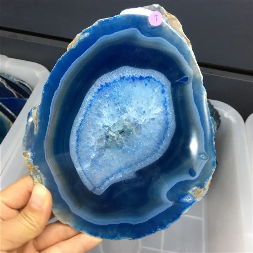 Blue geode held by a hand with a blurred background