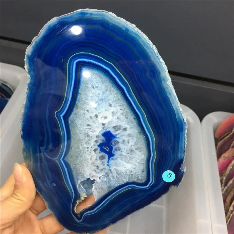 Blue agate stone held in a hand with a blurred background