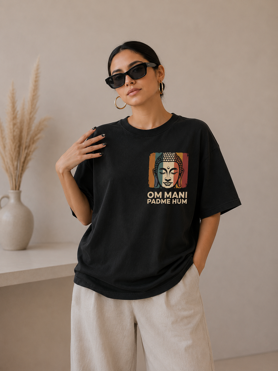 Person wearing a black t-shirt with a Buddha graphic and text, standing against a neutral background.