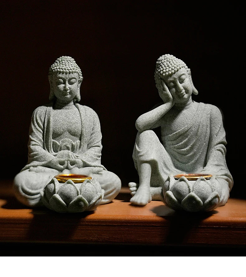 Two stone statues of Buddha sitting on lotus flowers with a dark background