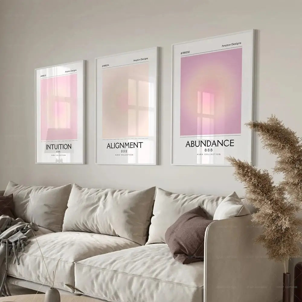 Three framed posters on a wall above a sofa with decorative elements.