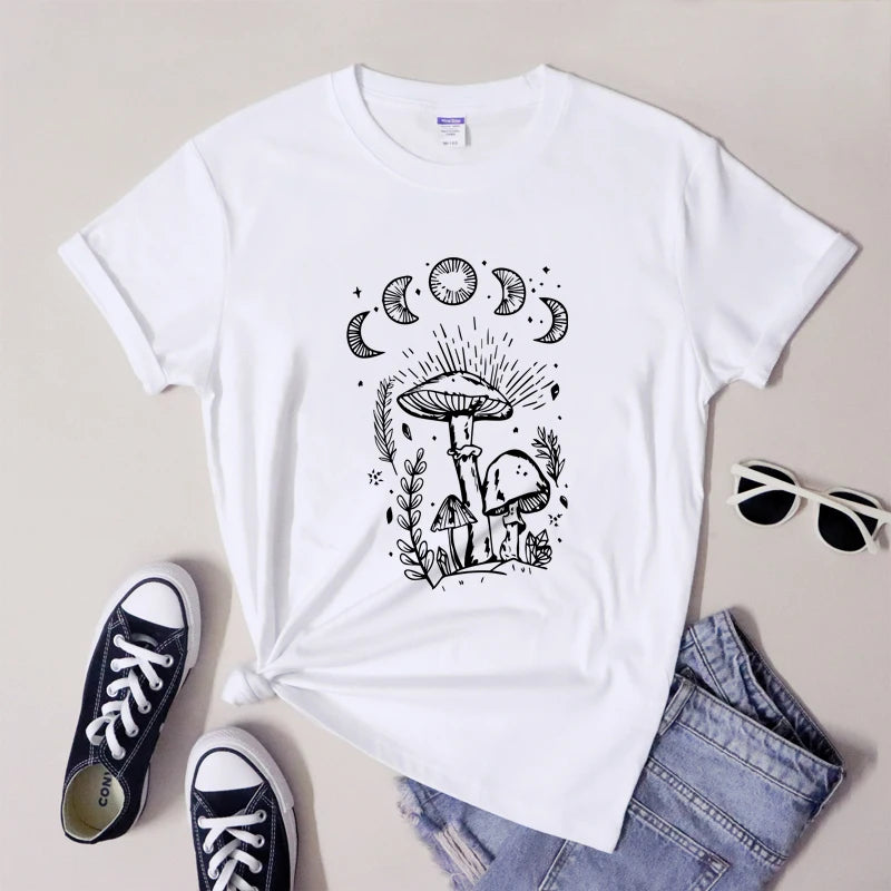 White t-shirt with black mushroom and moon design, paired with sneakers and sunglasses on a light background