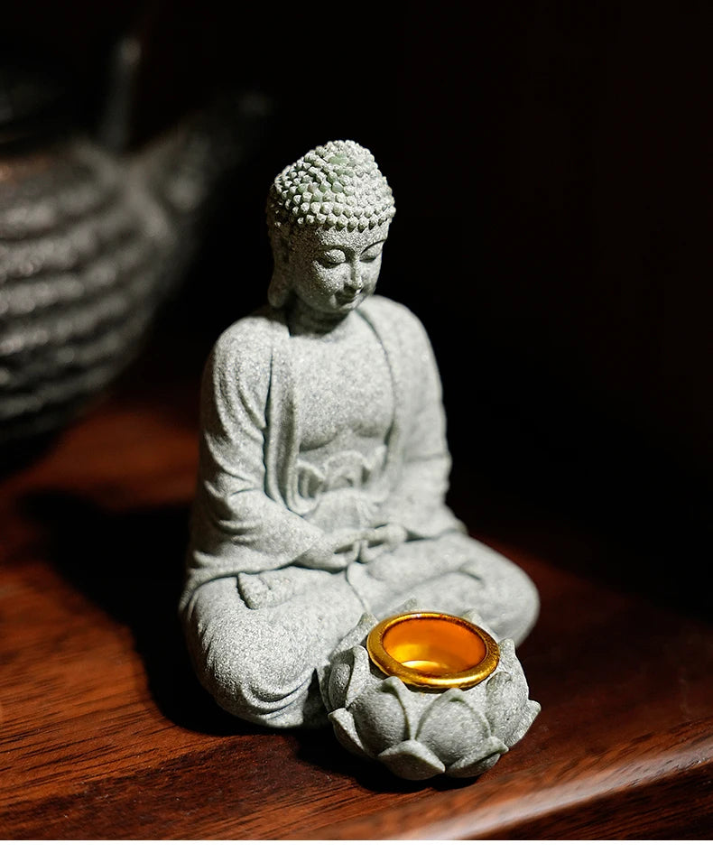 Buddha statue with a lit candle on a wooden surface